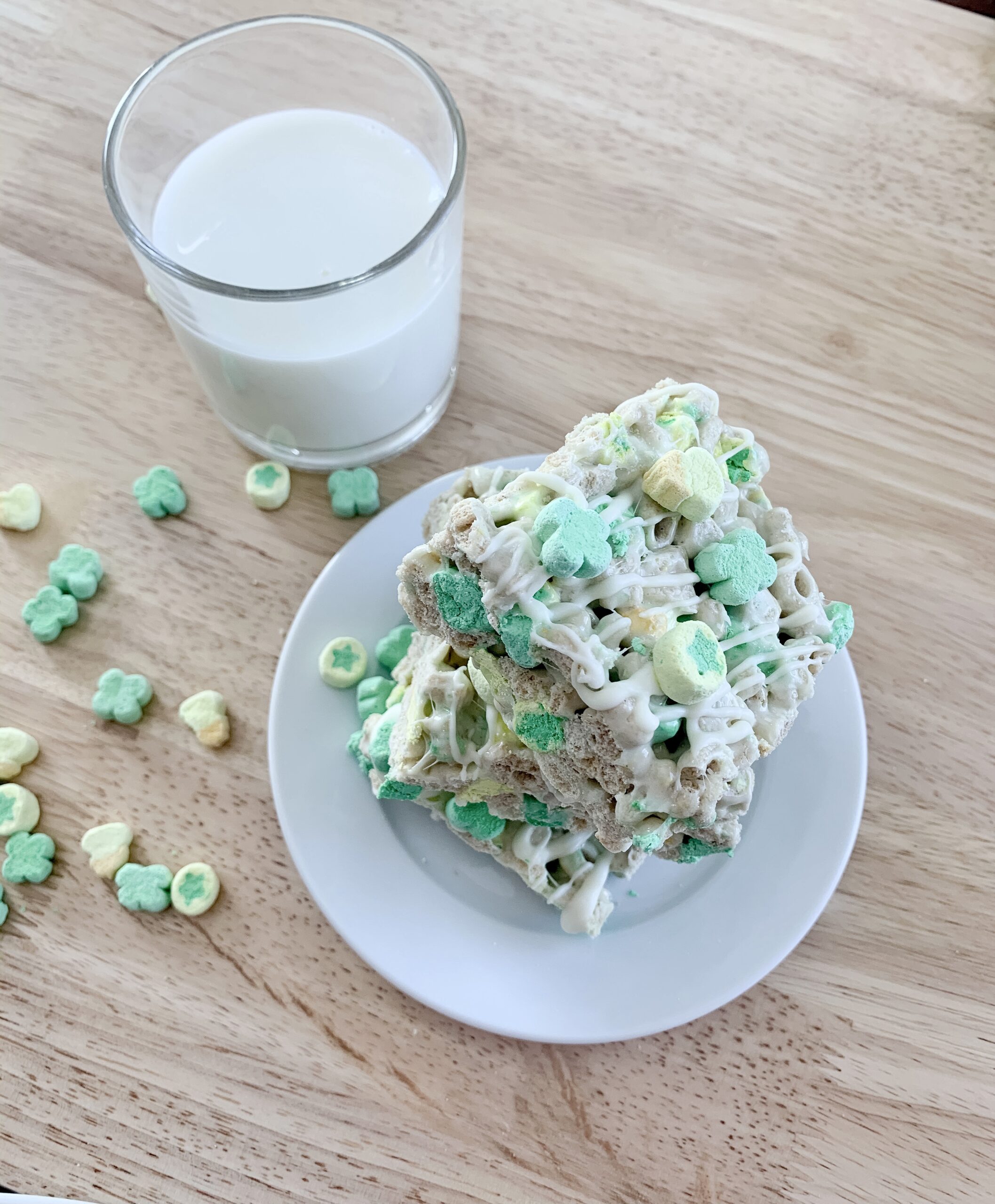 glass of milk with stack of Lucky Charms Treats