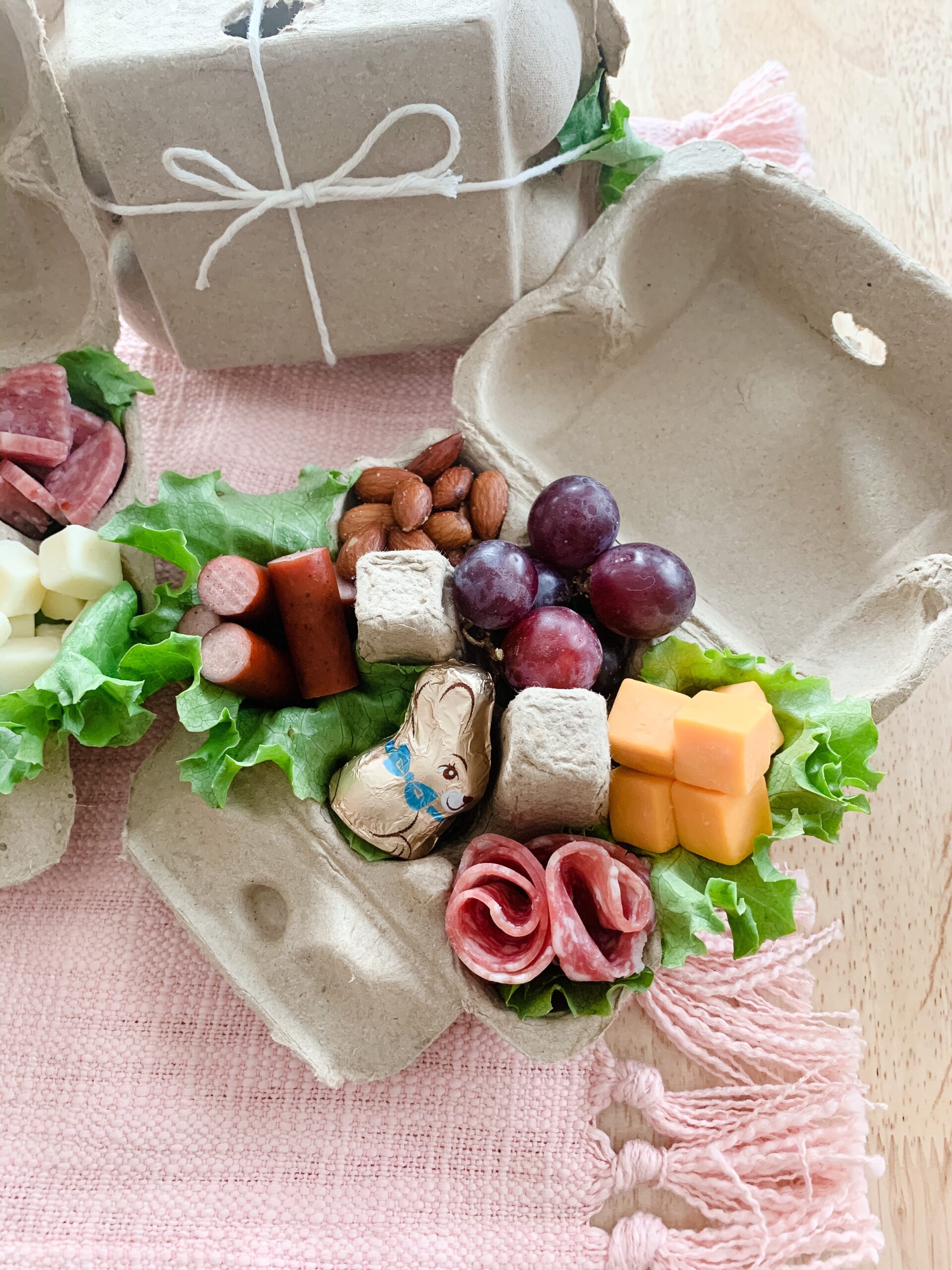 assorted meats and cheeses in an egg carton charcuterie