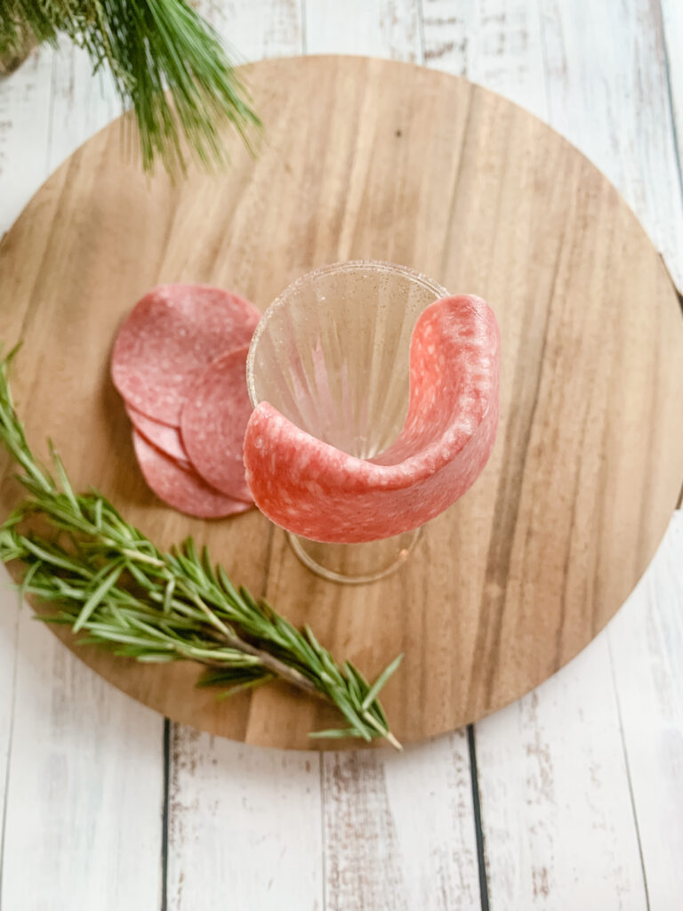 making a salami rosette using champagne glass